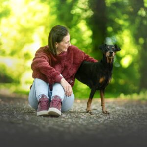 Sabine König Hundetrainer mit deutschem Pinscher im Park